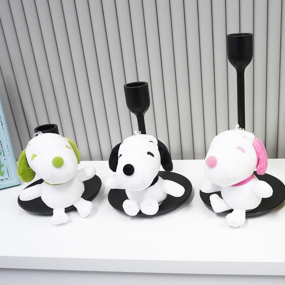Colorful Peanuts Snoopy plush toys in pink, green, and black displayed together