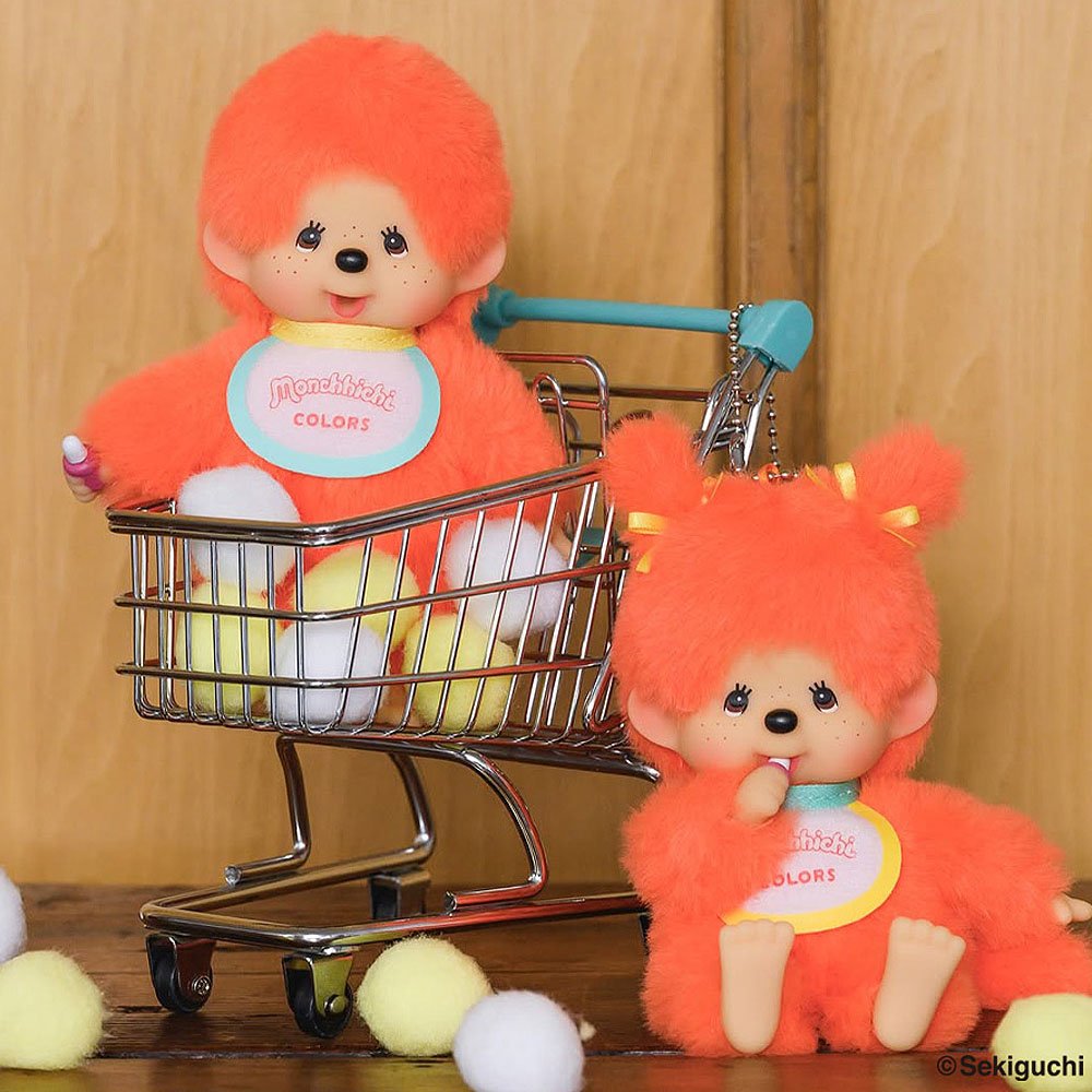Two orange Mochhichi plush toys with a small shopping cart on a wooden surface.