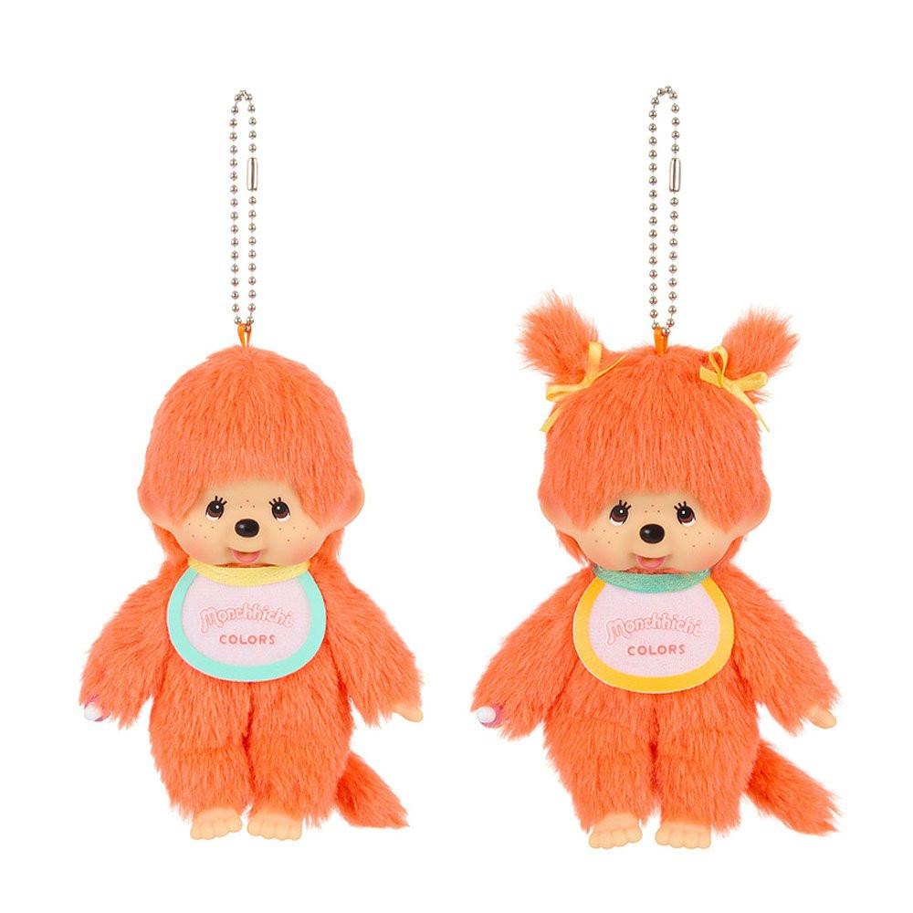 Two orange Monchhichi plush keychains with a small tag on a white background