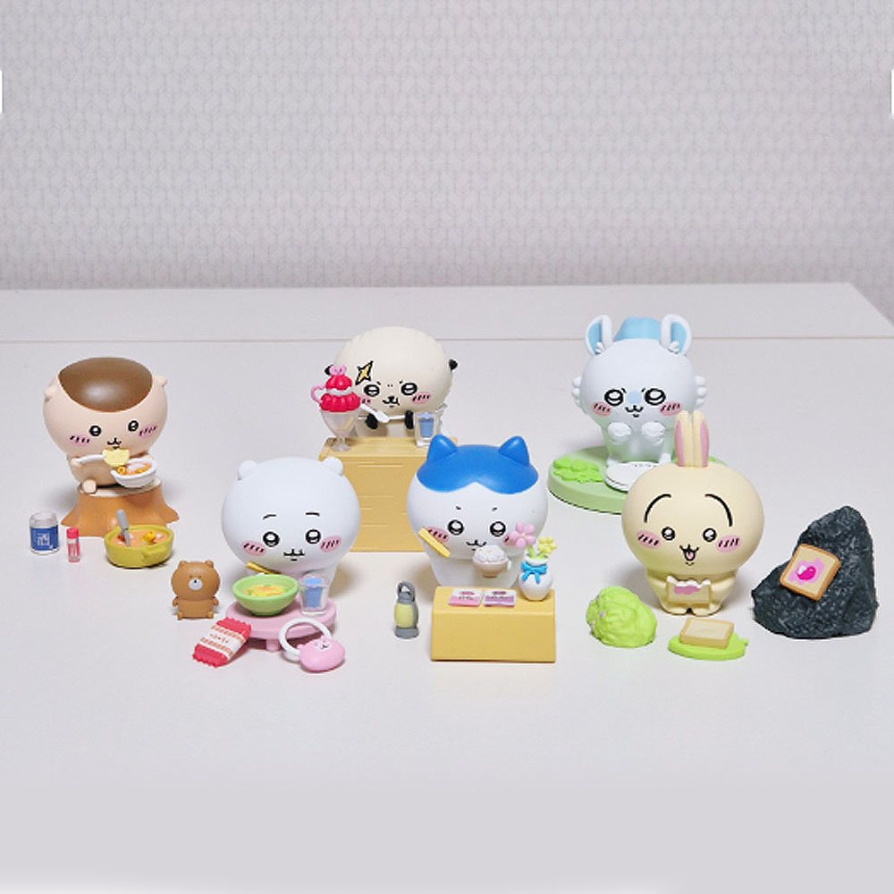 Set of small Chiikawa figurines with various poses and accessories on a white surface.