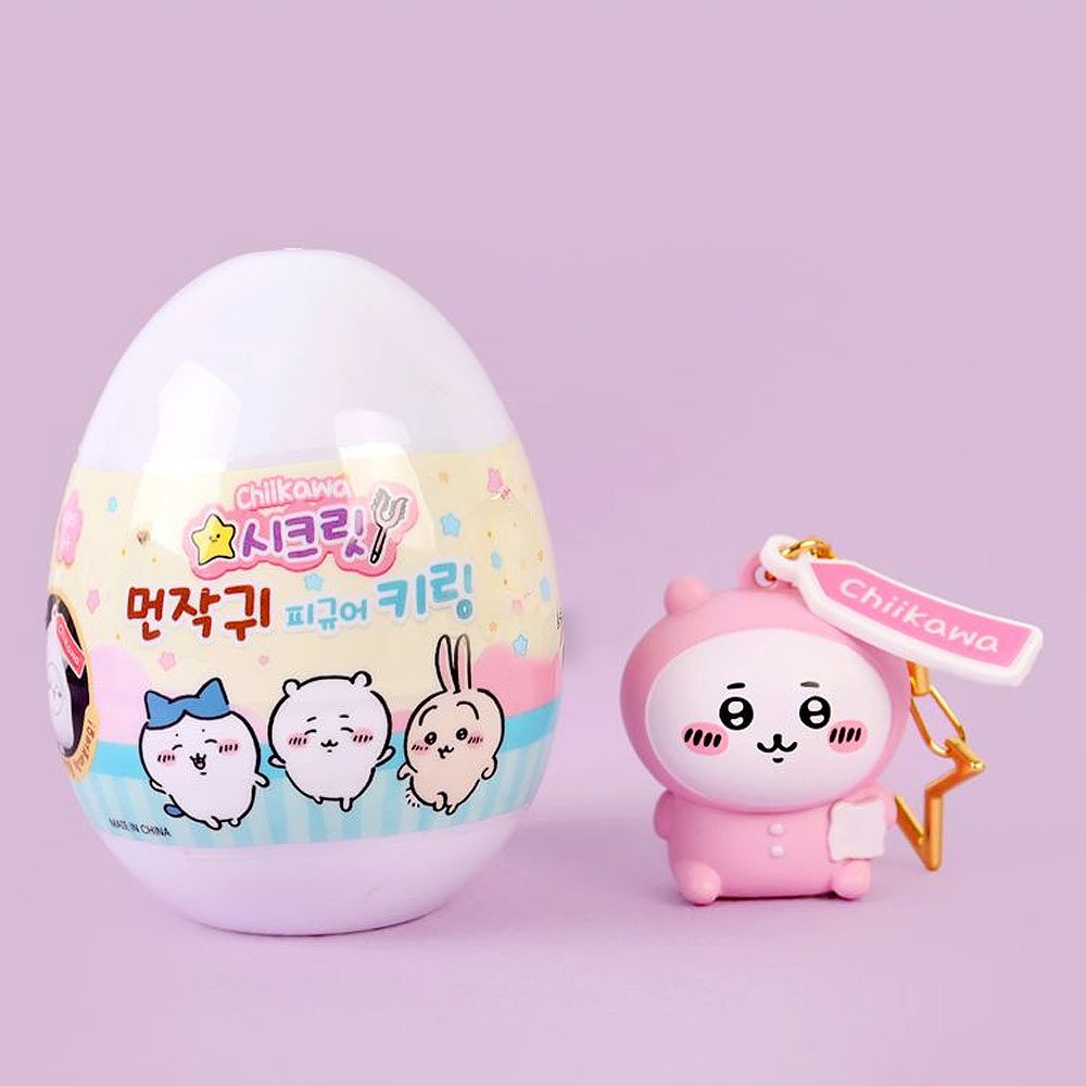 Pink chiikawa keychain with a colorful egg-shaped container on a light purple background
