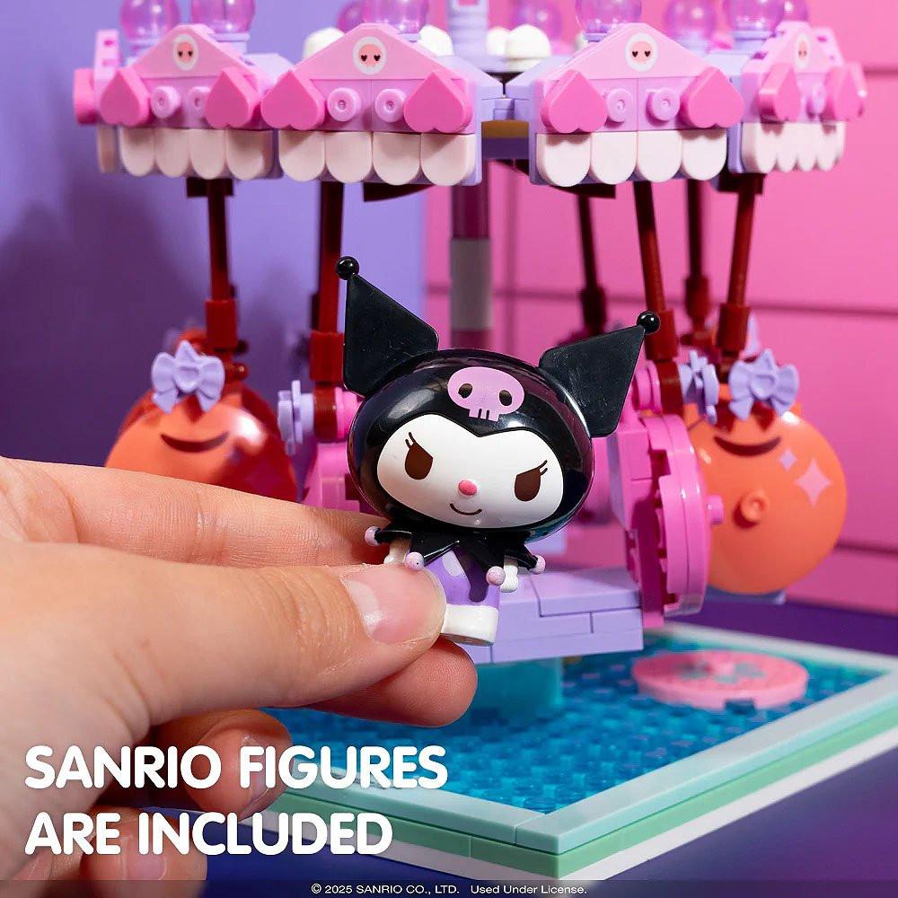 Hand holding a small Kuromi figure with a colorful toy set in the background.
