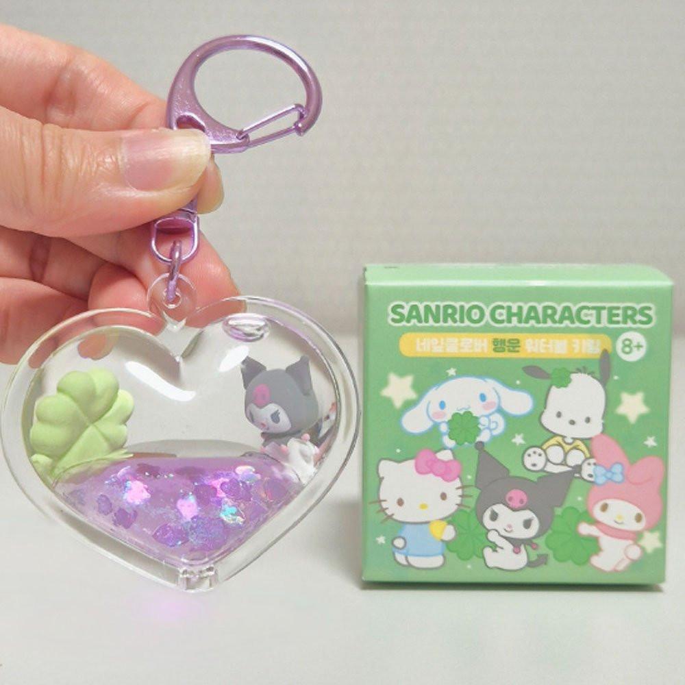 Heart-shaped keychain with Sanrio character Kuromi design and packaging in the background