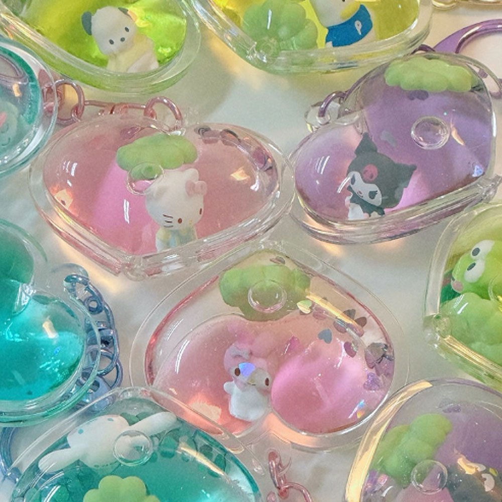 Collection of small figurines in transparent cases on a white background