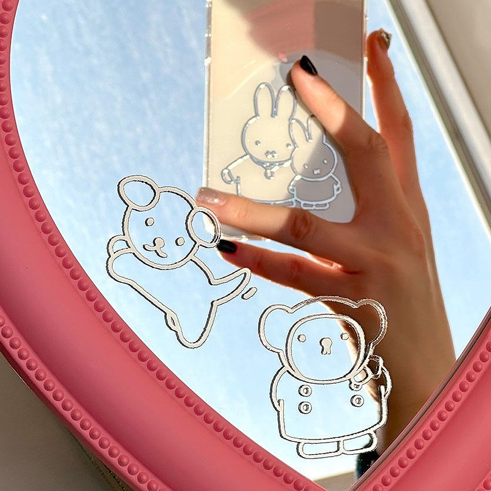 A person holding a smartphone with a 3D metal sticker of Miffy and Friends reflecting on the screen, with more stickers shown beside the phone.