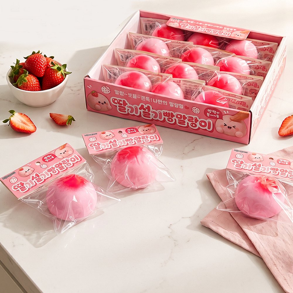 Retail display box and individually packaged pink Strawberry Rice Cake Bread Squishy Toys next to fresh strawberries, featuring stretchy mochi-like texture for stress relief, ideal party favor goodie bag filler and Christmas stocking stuffer gift