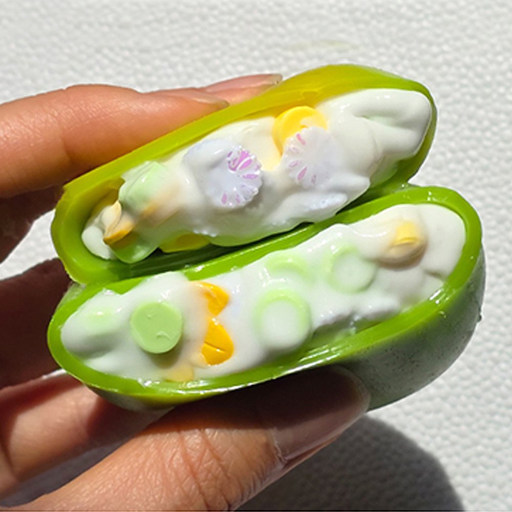 Squeezing open a green Sugar Mango Crunch Slime showing soft white stretchy slime filled with colorful crunch beads and yellow toppings inside, perfect Christmas gift and stress relief sensory toy