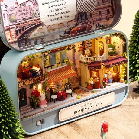 A intricate DIY miniature kit replicating a traditional Parisian cafe with a European designed facade, outdoor seating, and warm LED light