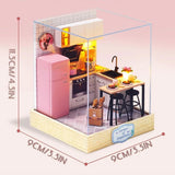 A detailed 3D DIY miniature kitchen model featuring a pink retro refrigerator, white cabinetry, and a small breakfast bar with stools