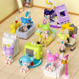 A collection of officially licensed building block sets featuring Baby Nanci in various home scenes like a bathtub, a bed, and next to a retro TV. The figures have colorful hair and are surrounded by pastel-colored furniture and accessories.