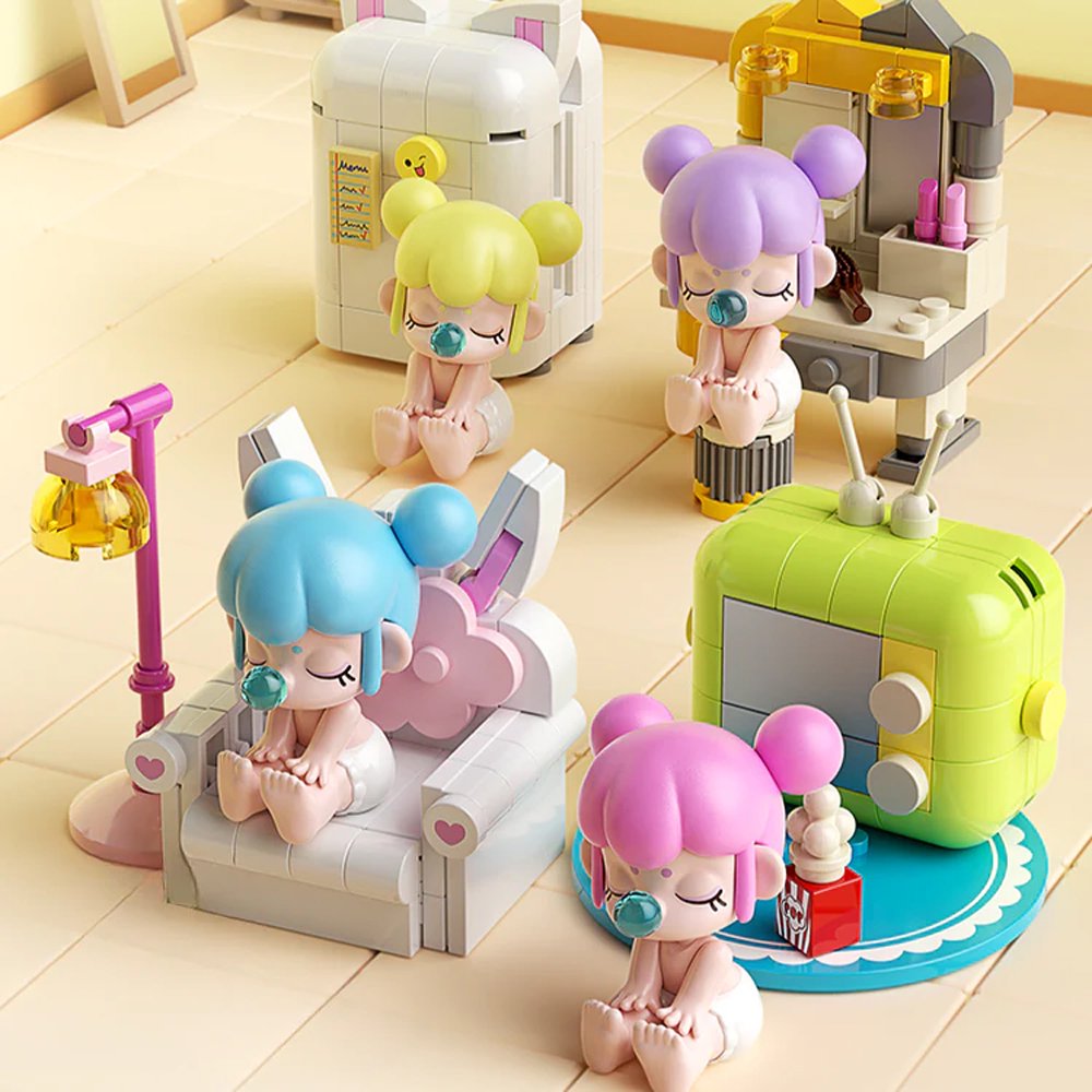 A collection of officially licensed building block sets featuring Baby Nanci in various home scenes like a bathtub, a bed, and next to a retro TV. The figures have colorful hair and are surrounded by pastel-colored furniture and accessories.