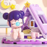 A collection of officially licensed building block sets featuring Baby Nanci in various home scenes like a bathtub, a bed, and next to a retro TV. The figures have colorful hair and are surrounded by pastel-colored furniture and accessories.