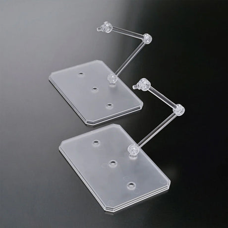 Two officially licensed Bandai Action Base 6 stands in clear plastic. Each features a rectangular base and an articulated support arm, customized with different plastic stickers showing portraits of characters like Suletta, Miorine, Guel, Shaddiq, and Elan.