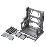 An officially licensed Bandai System Base 001 model kit display stand in metallic gunmetal gray. The retail packaging shows the mechanical hangar holding 1/144 scale Gunpla figures, highlighting its adjustable structural parts and industrial detail.
