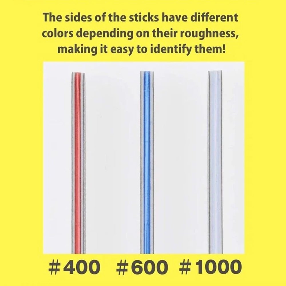 A set of three Bandai Spirits model sanding sticks in their retail packaging, featuring red, blue, and white color-coded edges. Each gray abrasive stick is displayed next to the package to show the different grit levels for plastic model finishing.