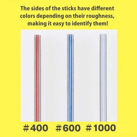 A set of three Bandai Spirits model sanding sticks in their retail packaging, featuring red, blue, and white color-coded edges. Each gray abrasive stick is displayed next to the package to show the different grit levels for plastic model finishing.