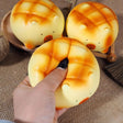 Soft capybara-shaped melon pan bread squishy toys with golden-brown baked textures and minimalist facial features