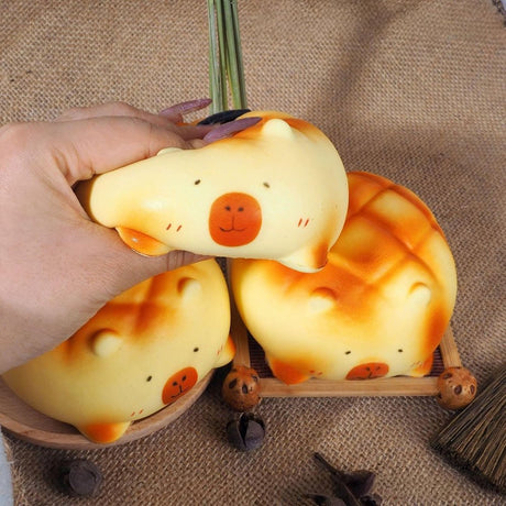 Soft capybara-shaped melon pan bread squishy toys with golden-brown baked textures and minimalist facial features