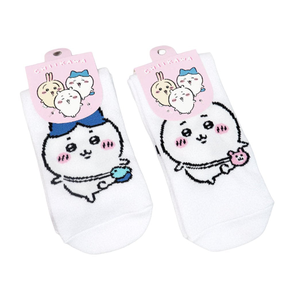 Featuring the pairs of officially licensed Chiikawa white crew-length socks, pink one holding a pink bear crossbody pouch and blue one holding a blue fish crossbody pouch.