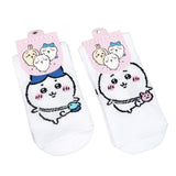 Featuring the pairs of officially licensed Chiikawa white crew-length socks, pink one holding a pink bear crossbody pouch and blue one holding a blue fish crossbody pouch.
