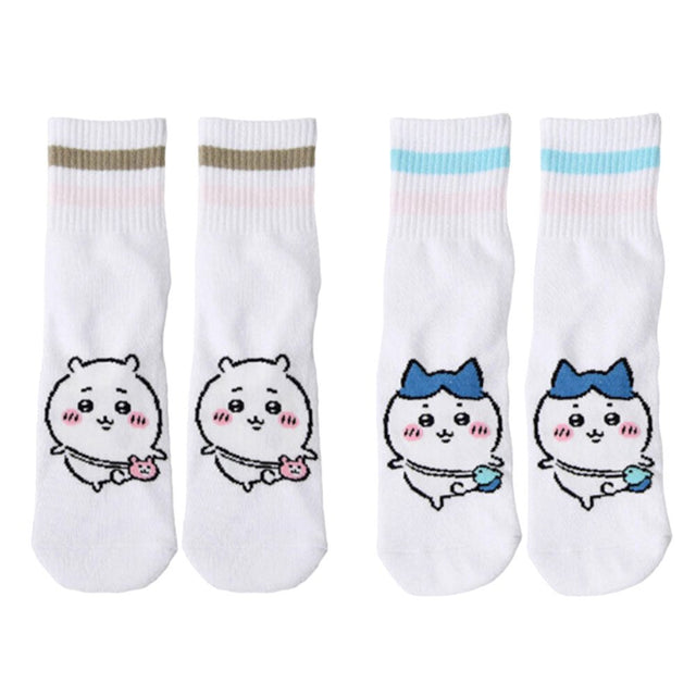 Featuring the pairs of officially licensed Chiikawa white crew-length socks, pink one holding a pink bear crossbody pouch and blue one holding a blue fish crossbody pouch.