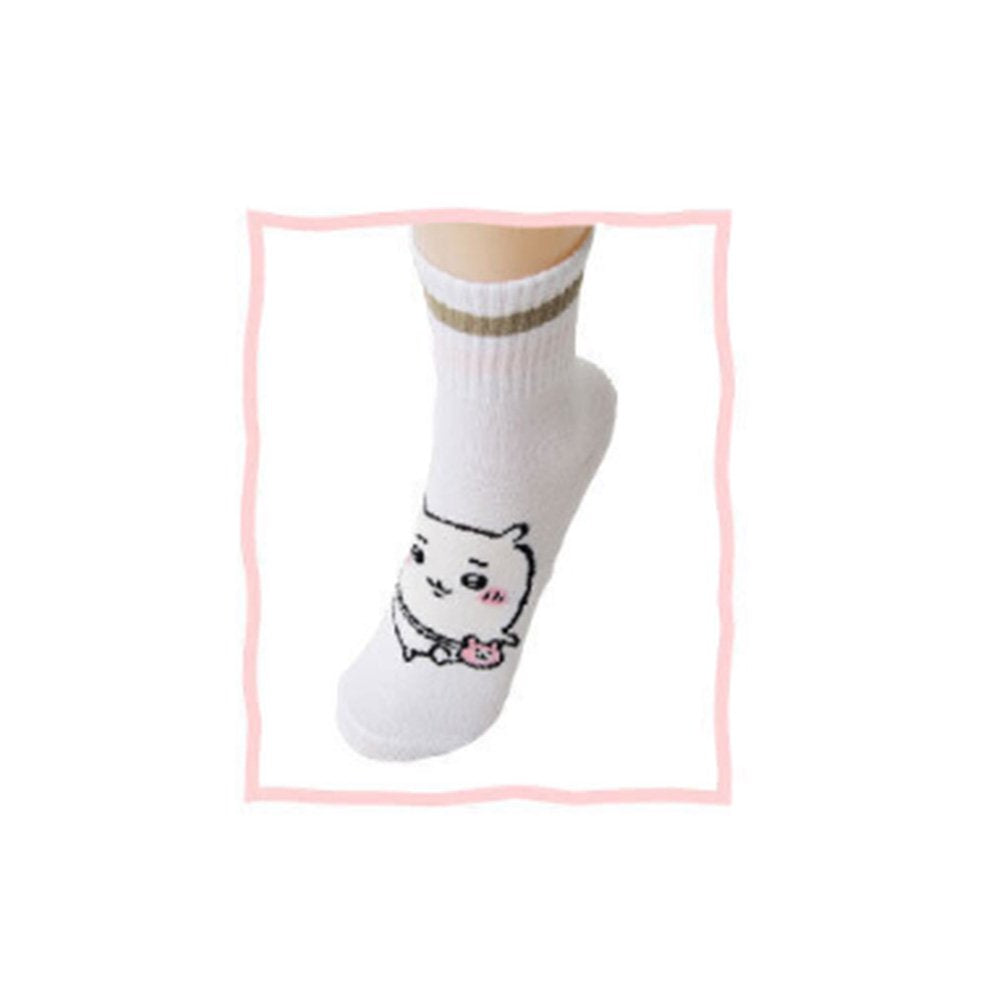 Featuring the pairs of officially licensed Chiikawa white crew-length socks, pink one holding a pink bear crossbody pouch and blue one holding a blue fish crossbody pouch.