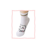 Featuring the pairs of officially licensed Chiikawa white crew-length socks, pink one holding a pink bear crossbody pouch and blue one holding a blue fish crossbody pouch.