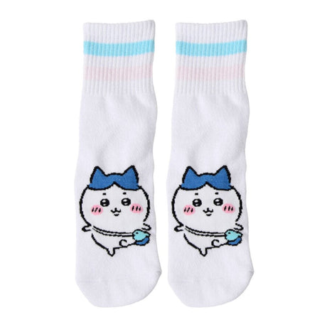Featuring the pairs of officially licensed Chiikawa white crew-length socks, pink one holding a pink bear crossbody pouch and blue one holding a blue fish crossbody pouch.