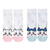 Featuring the pairs of officially licensed Chiikawa white crew-length socks, pink one surrounded by small pink-and-white flowers and blue one surrounded by blue-and-yellow flowers.