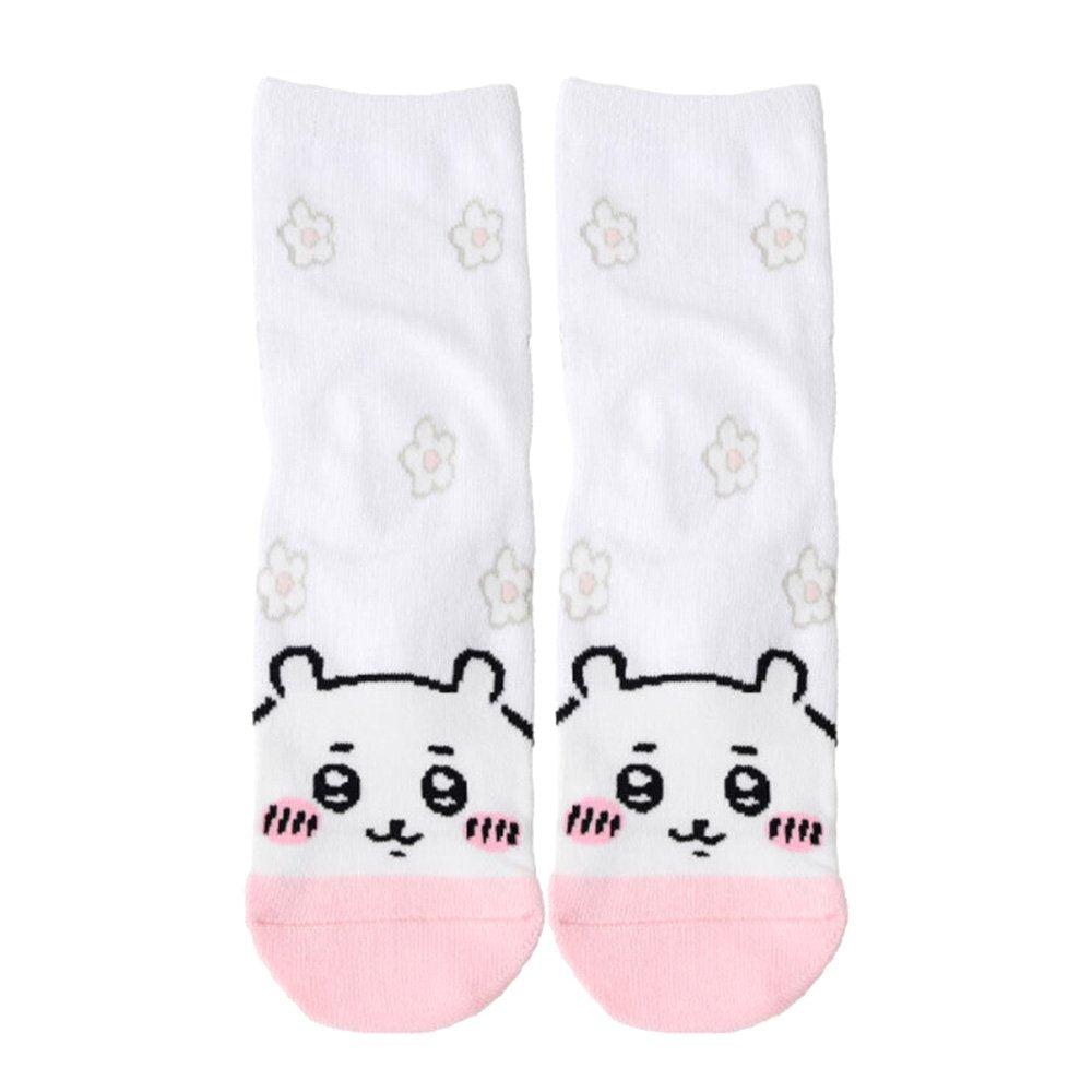 Featuring the pairs of officially licensed Chiikawa white crew-length socks, pink one surrounded by small pink-and-white flowers and blue one surrounded by blue-and-yellow flowers.
