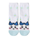 Featuring the pairs of officially licensed Chiikawa white crew-length socks, pink one surrounded by small pink-and-white flowers and blue one surrounded by blue-and-yellow flowers.