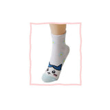 Featuring the pairs of officially licensed Chiikawa white crew-length socks, pink one surrounded by small pink-and-white flowers and blue one surrounded by blue-and-yellow flowers.