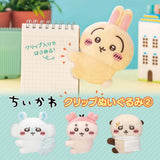 Officially licensed Chiikawa plush clip character assortment featuring Usagi clipped onto a spiral notebook cover alongside mini plush clips of Momonga, Kani, and Rakko
