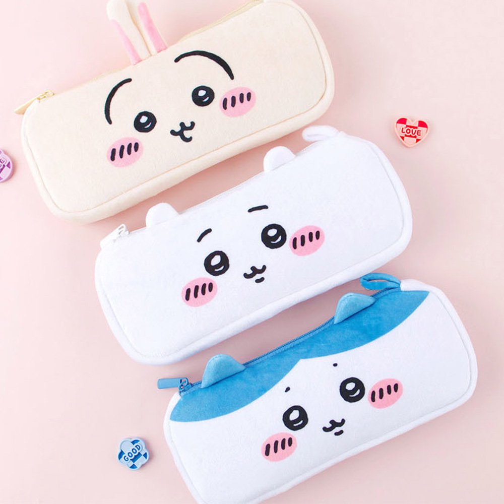 Three officially licensed plush Chiikawa character pencil cases featuring: the yellow-colored with Usagi's face and long ears; the white with Chiikawa's face; the white and blue with Hachiware's face and blue ears. Each pouch features embroidered eyes, pink cheeks, and a top zipper.