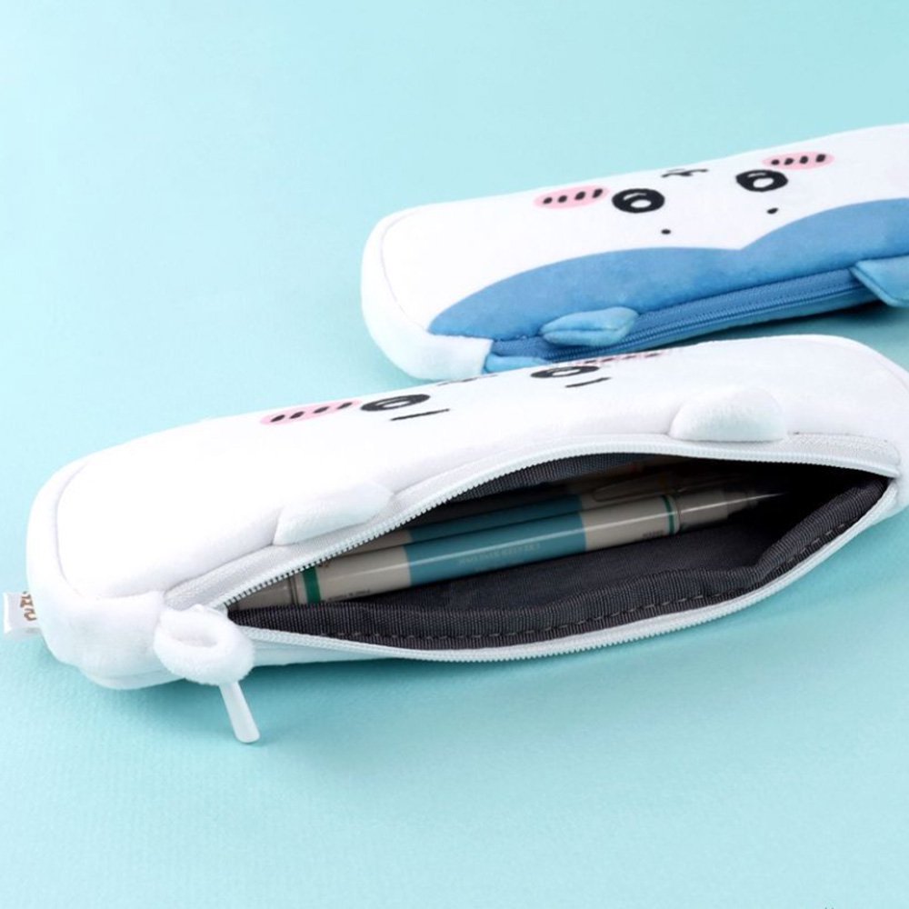 Three officially licensed plush Chiikawa character pencil cases featuring: the yellow-colored with Usagi's face and long ears; the white with Chiikawa's face; the white and blue with Hachiware's face and blue ears. Each pouch features embroidered eyes, pink cheeks, and a top zipper.