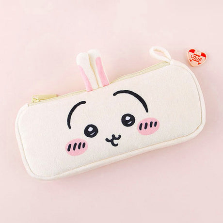 Three officially licensed plush Chiikawa character pencil cases featuring: the yellow-colored with Usagi's face and long ears; the white with Chiikawa's face; the white and blue with Hachiware's face and blue ears. Each pouch features embroidered eyes, pink cheeks, and a top zipper.