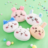 A group of five officially licensed Chiikawa plush face charms, including characters like Chiikawa, Hachiware, and Usagi, shown with colorful ears and pink blushing cheeks. Each round, soft mascot features a pink hanging loop.