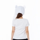 A woman viewed from behind wearing a white short-sleeve T-shirt and a white knit beanie with small Chiikawa Momonga, against a plain white background.