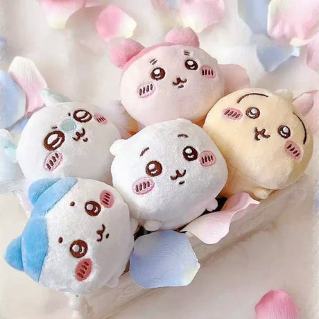 An collection of five officially licensed Chiikawa "nesoberi" laying-down plush toys, featuring the characters Chiikawa, Hachiware, Usagi, Momonga, and Kani against a green polka-dot background. The plushies are small, rounded, and white, blue, yellow, and pink in color with sweet embroidered faces.