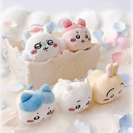 An collection of five officially licensed Chiikawa "nesoberi" laying-down plush toys, featuring the characters Chiikawa, Hachiware, Usagi, Momonga, and Kani against a green polka-dot background. The plushies are small, rounded, and white, blue, yellow, and pink in color with sweet embroidered faces.