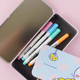 Two rectangular tin pencil cases featuring officially licensed Chiikawa artwork. One is light blue with white polka dots showing Chiikawa and a yellow claw machine hand. The other one has a pink-to-purple sunset gradient showing Chiikawa and Hachiware sitting on stumps and drinking.