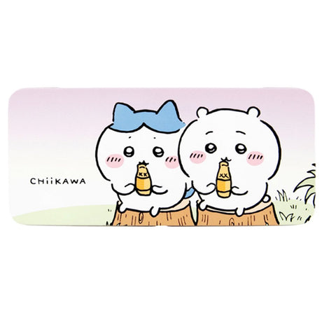 Two rectangular tin pencil cases featuring officially licensed Chiikawa artwork. One is light blue with white polka dots showing Chiikawa and a yellow claw machine hand. The other one has a pink-to-purple sunset gradient showing Chiikawa and Hachiware sitting on stumps and drinking.