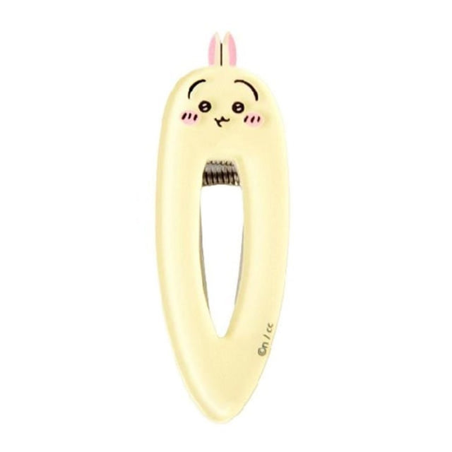 Pastel yellow teardrop-shaped Usagi character hair clip from Chiikawa featuring a minimalist blushing face, rabbit ears, and a sturdy metal spring mechanism.
