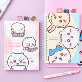 Officially licensed Chiikawa spiral notebooks with index tabs, featuring Chiikawa studying on a pink cover, while the other shows the trio on a yellow and blue background; both include built-in tabs shaped like a bear, a camera, and an acorn.