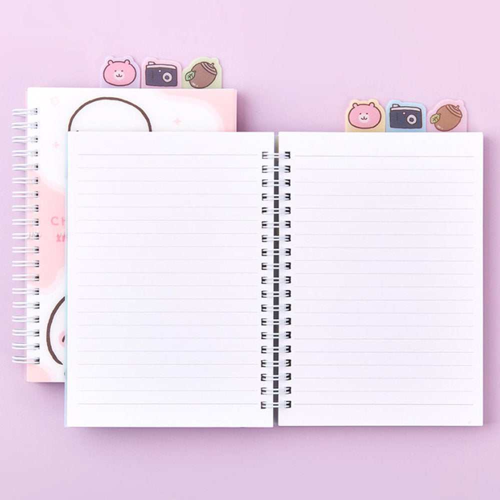 Officially licensed Chiikawa spiral notebooks with index tabs, featuring Chiikawa studying on a pink cover, while the other shows the trio on a yellow and blue background; both include built-in tabs shaped like a bear, a camera, and an acorn.