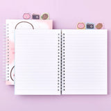 Officially licensed Chiikawa spiral notebooks with index tabs, featuring Chiikawa studying on a pink cover, while the other shows the trio on a yellow and blue background; both include built-in tabs shaped like a bear, a camera, and an acorn.