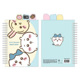 Officially licensed Chiikawa spiral notebooks with index tabs, featuring Chiikawa studying on a pink cover, while the other shows the trio on a yellow and blue background; both include built-in tabs shaped like a bear, a camera, and an acorn.