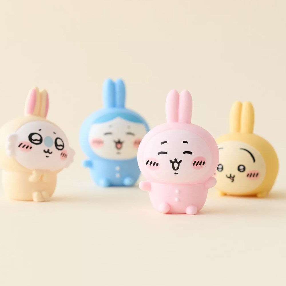 Officially licensed Chiikawa soft vinyl figures featuring Chiikawa, Hachiware, Momonga, and Usagi wearing colorful bunny-ear outfits
