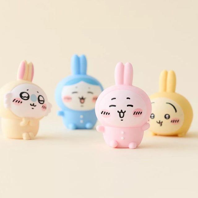 Officially licensed Chiikawa soft vinyl figures featuring Chiikawa, Hachiware, Momonga, and Usagi wearing colorful bunny-ear outfits
