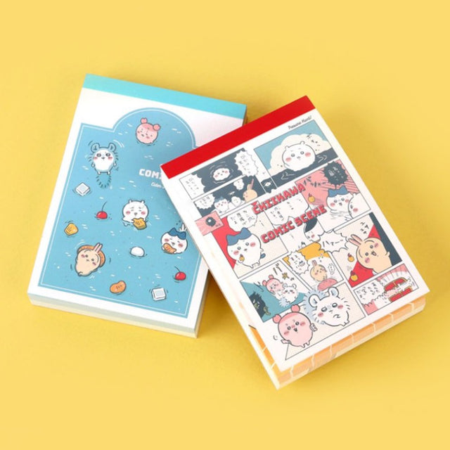 Officially licensed Chiikawa memo pads, one featuring a blue aquatic theme and the other a colorful comic book panel design. The interior pages show detailed character illustrations of Chiikawa, Hachiware, and Usagi.